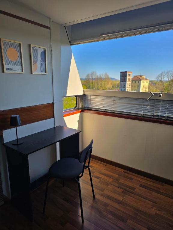 a desk and a chair in a room with a window at Residenza 402 in Ivrea