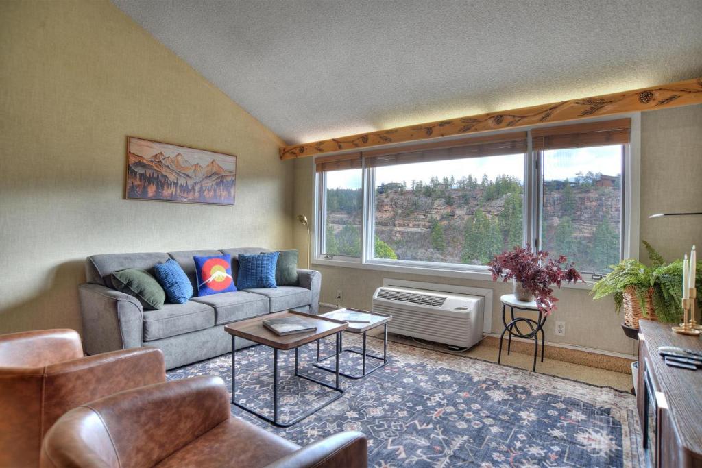 a living room with a couch and a large window at Tamarron Lodge Loft 510 in Durango