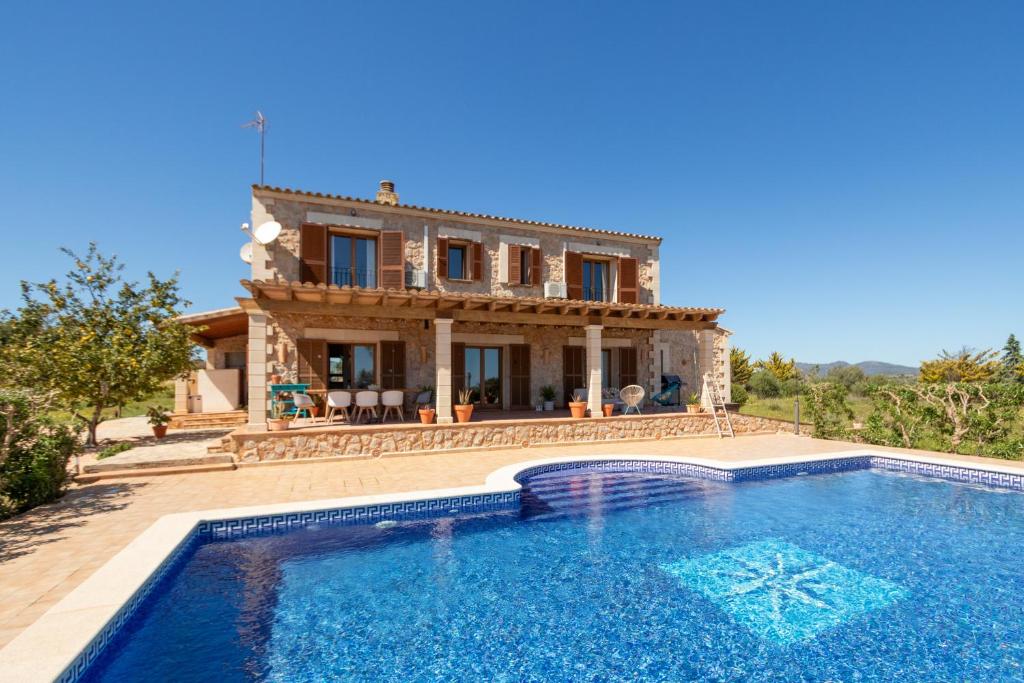 a villa with a swimming pool in front of a house at Idyllische Natur-Finca mit 12m Pool & Meerblick in Porto Cristo