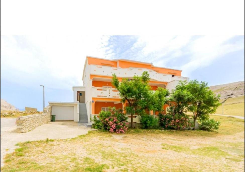 an orange and white house with some bushes and trees at Sea & Mountain View Apartments - Metajna in Metajna