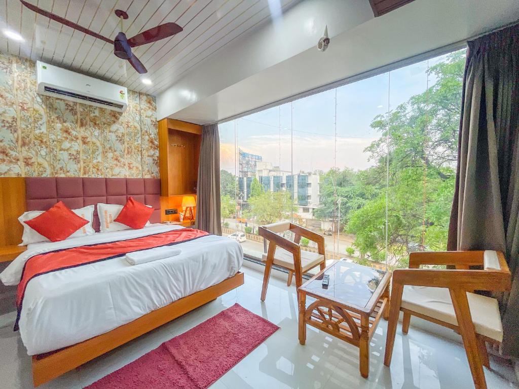 a bedroom with a bed and a large window at Hotel ShivSundar Executive in Aurangabad