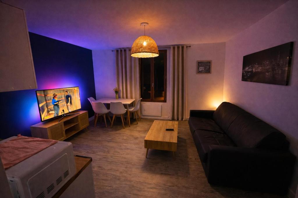 a living room with a couch and a table at Le cocon de corbeil in Corbeil-Essonnes
