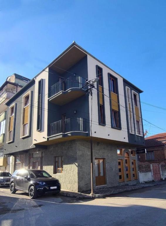a building with a car parked in front of it at Hotel Velar in Korçë