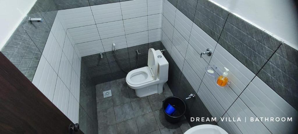 a bathroom with a white toilet in a stall at W Villas in Padinjarathara