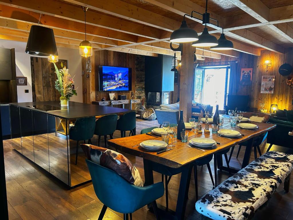 a dining room with a long table and chairs at Le chalet des fontaines in Allos