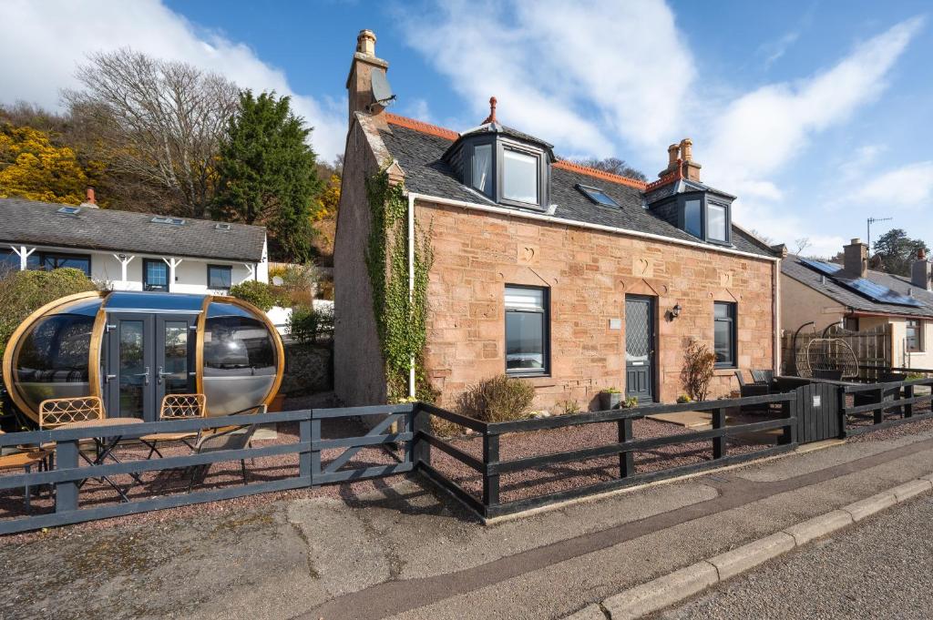 a house with a van parked in front of it at Shore View Cottage in Inverness