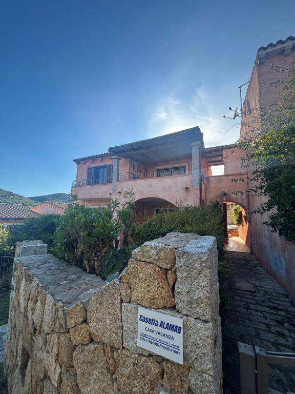 a stone wall in front of a building at Casetta Alamar in San Teodoro