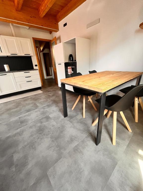 a kitchen and dining room with a wooden table and chairs at Mansarda Mitta Coel in Torre di Santa Maria
