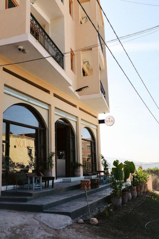 a house with a balcony and a table and chairs at NOUR Tamraght in Tamraght Ouzdar