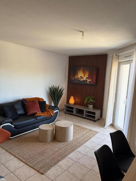 a living room with a couch and a fireplace at La Pause Larzac- T3 calme-terrasse - Proche Viaduc de Millau in La Cavalerie