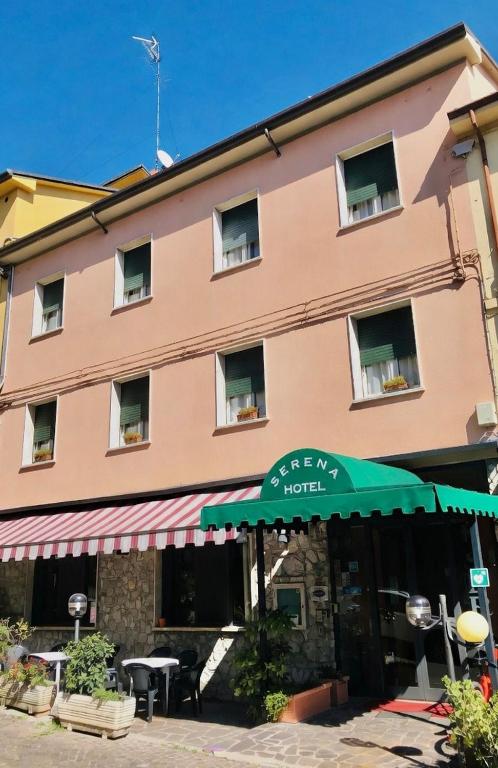 a building with a green umbrella in front of it at Hotel Serena in Riolo Terme