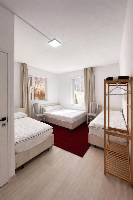 a bedroom with three beds and a ladder in it at Infinity Hotel in Cholpon-Ata