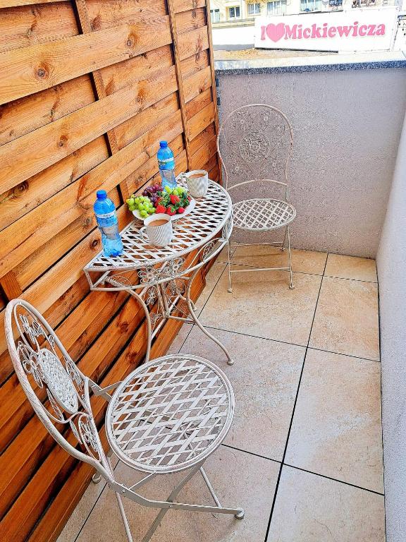 a patio with two chairs and a table with a bowl of fruit at Poznaj Mickiewicza 4 in Racibórz
