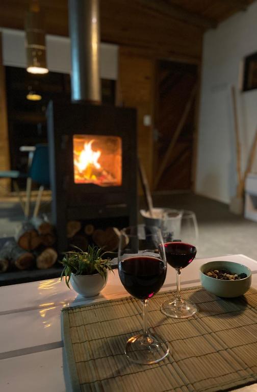 two glasses of wine on a table in front of a fireplace at Mandalas de Mar in Punta Del Diablo