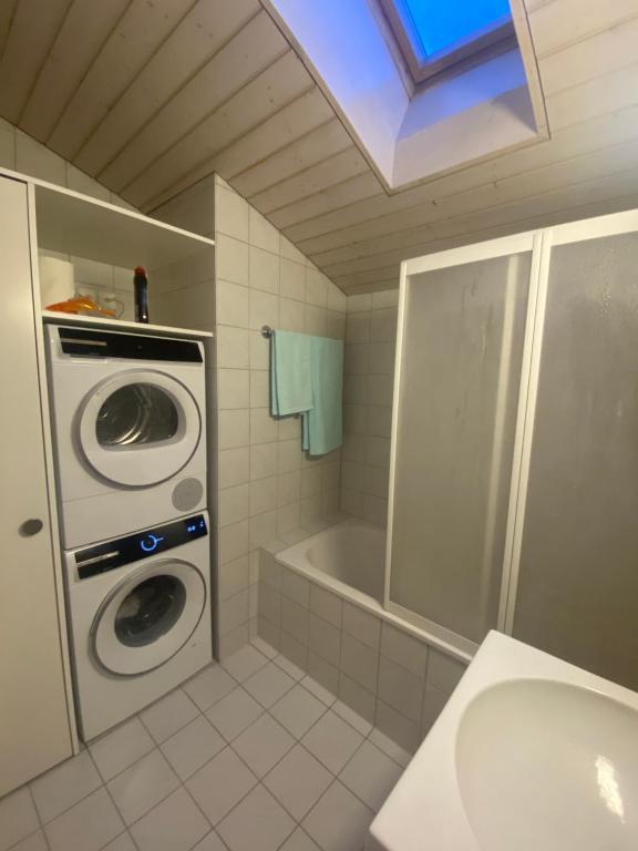 a bathroom with a washing machine and a sink at Wachtgasse in Adliswil