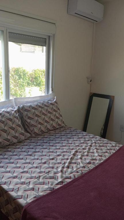 a large bed in a room with a window at Casa próxima a orla in Pelotas