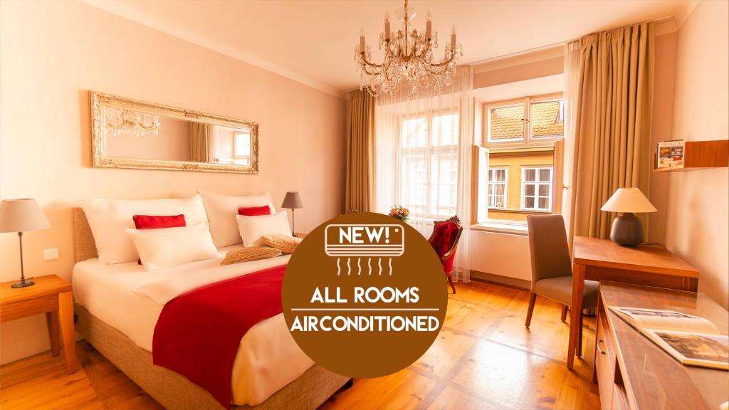 a hotel room with a bed and a chandelier at Hotel Golden Key Prague Castle in Prague