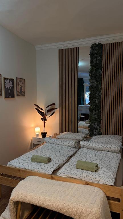 three beds in a room with a mirror at Boldog Deluxe apartman in Szolnok