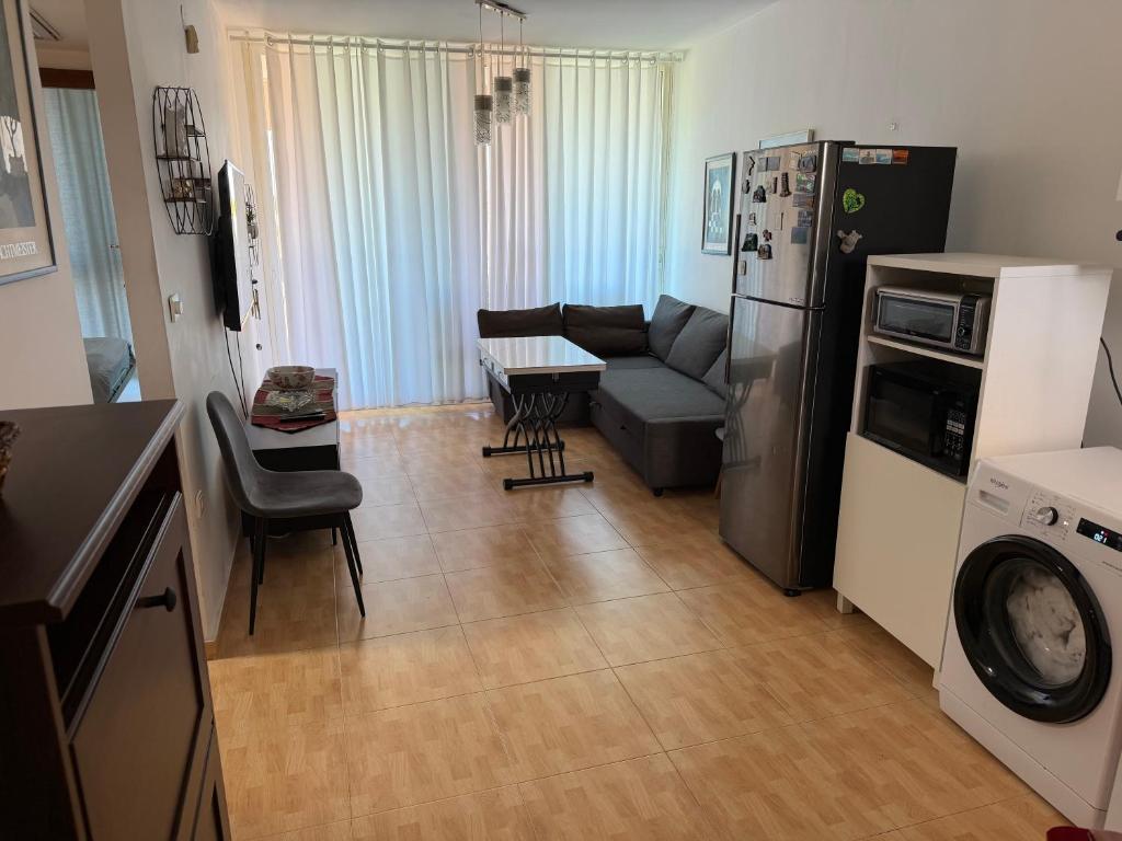a kitchen and living room with a couch and a refrigerator at Sea view apartments in Caesarea