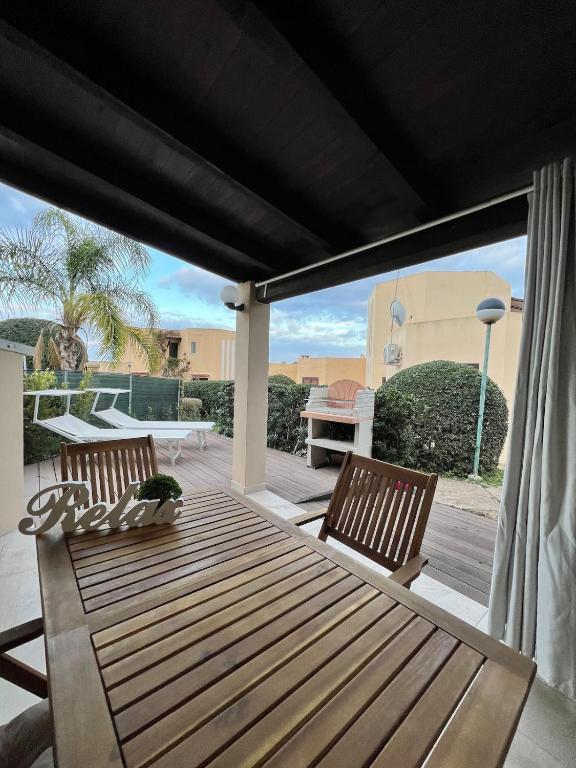 a patio with a wooden table and two chairs at Casa Anna in Costa Rei