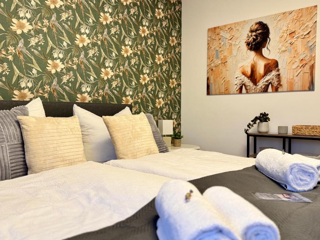 two beds in a bedroom with a painting on the wall at FeWo Pelkmann Apartment 1 - Die Grüne Oase - Garten & Terrasse in Weikersheim
