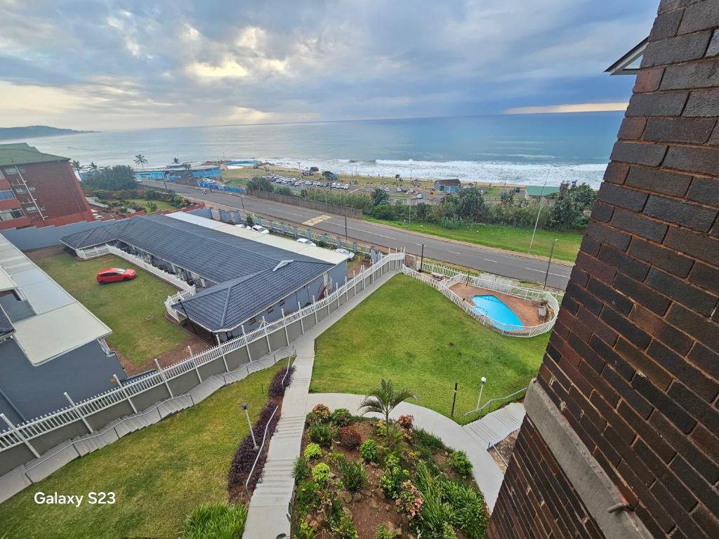 an aerial view of a building with a pool and the ocean at Ocean Whisper 405 in Scottburgh