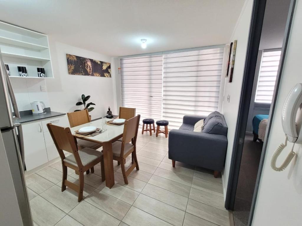 a kitchen and living room with a table and a couch at Depto Comodo y full equipado in Antofagasta