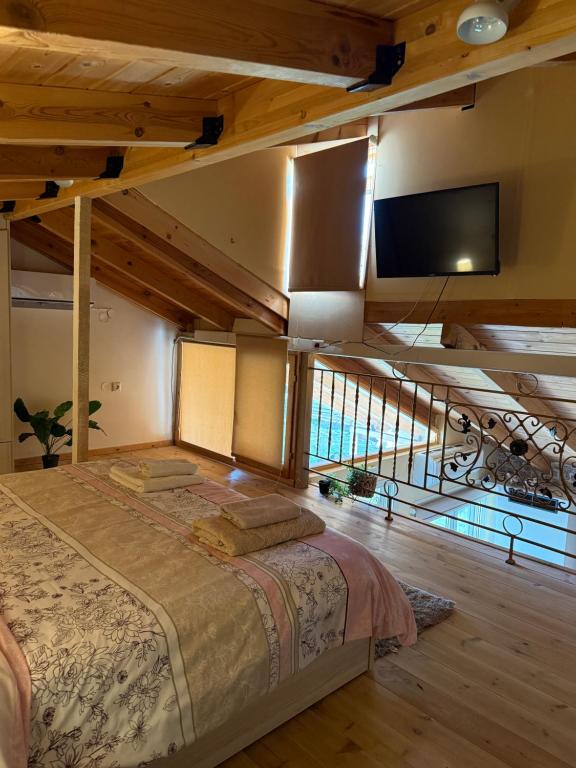 a bedroom with a bed and a flat screen tv at The Countryside Loft in Katsikás