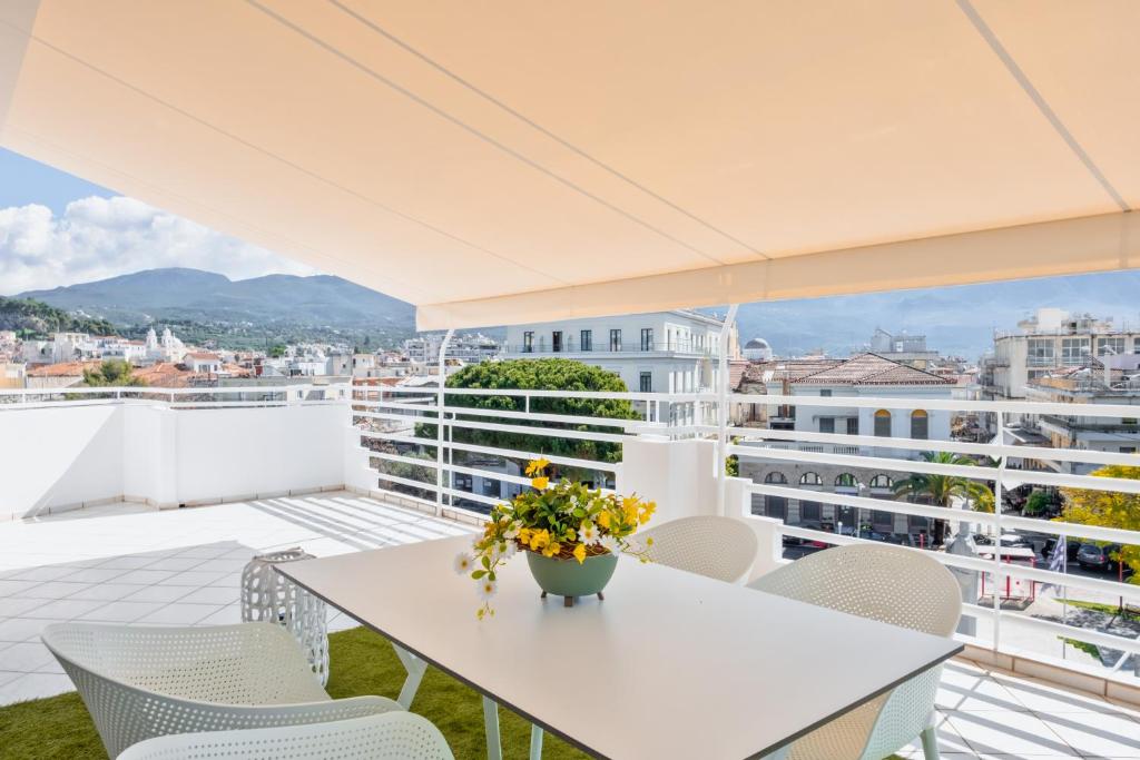 a white table and chairs on a balcony with a view at Downtown Skyloft in Kalamata