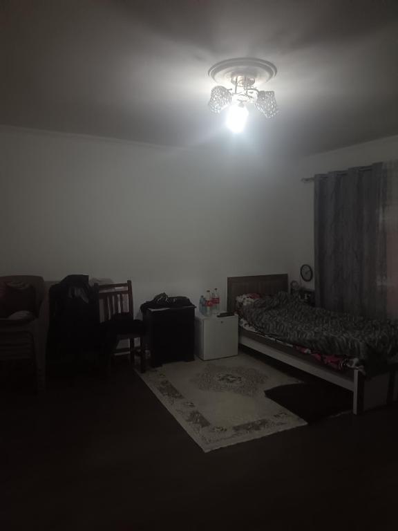 a dark room with a bed and a chandelier at Mikel rooms in Peshkopi