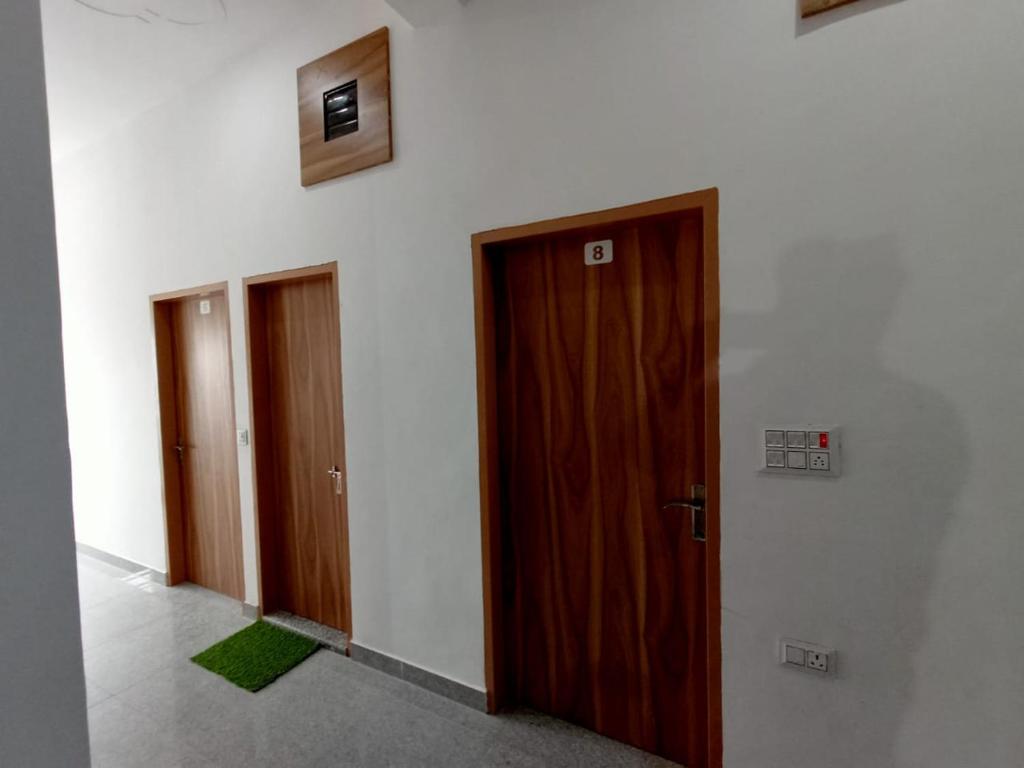 a row of three doors in a room at Hotel Swami in Gogameri