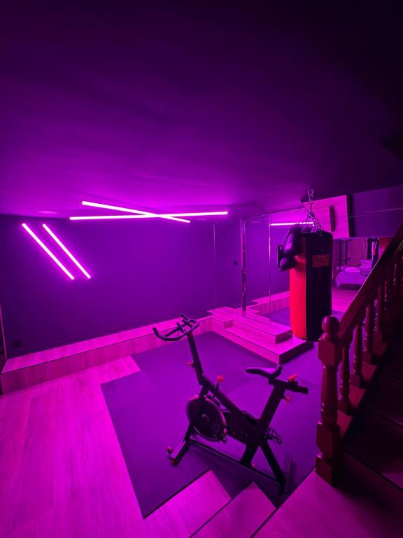 a room with a gym with purple lights and a treadmill at Nómada Orzán bajo in A Coruña