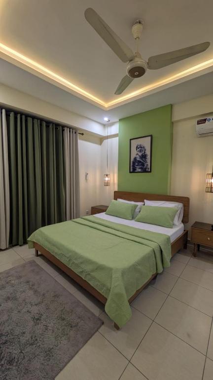 a bedroom with a large bed with green walls at Dreamland royal suite in Rawalpindi