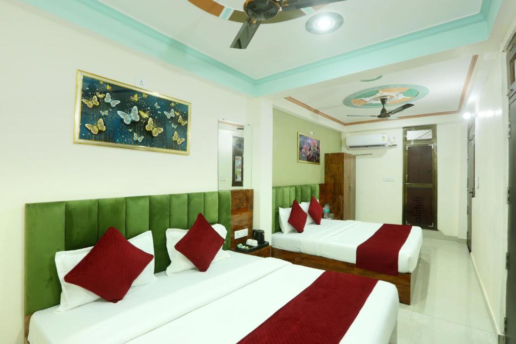 a bedroom with two beds and a ceiling fan at Hotel Radha Rani palace in Ayodhya
