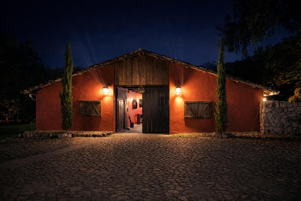 a red building with a garage at night at Hacienda San Francisco in Tumbabiro