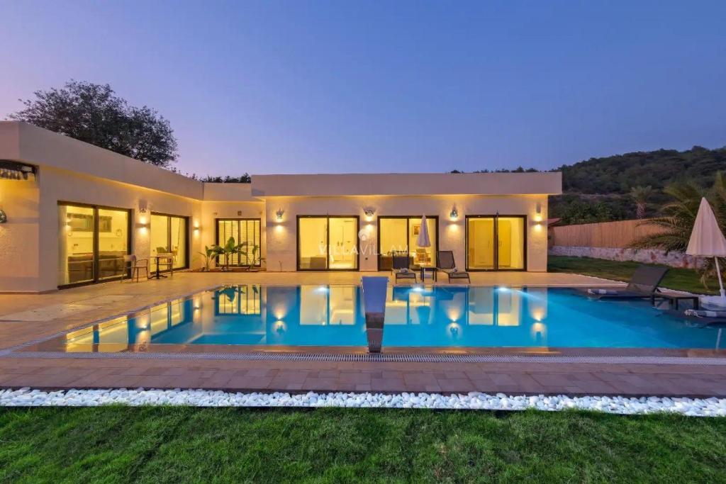 a villa with a swimming pool at night at villa tera Private Pool & jacuzzi in Fethiye