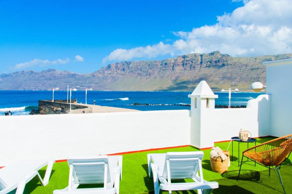 a patio with chairs and a view of the ocean at Muellito de Famara in Famara