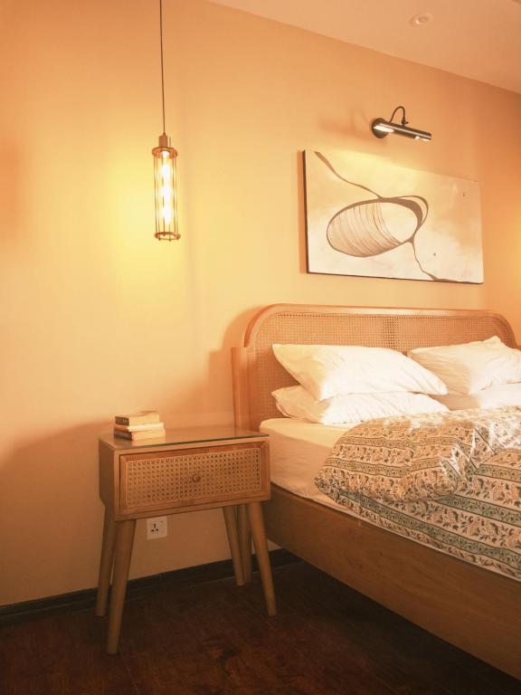 a bedroom with a bed and a side table at Maison Veyra in Rawalpindi