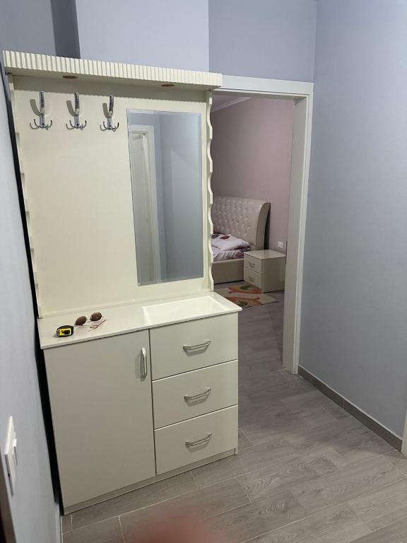 a bathroom with a mirror and a white dresser at Azure Pine Apartament in Golem
