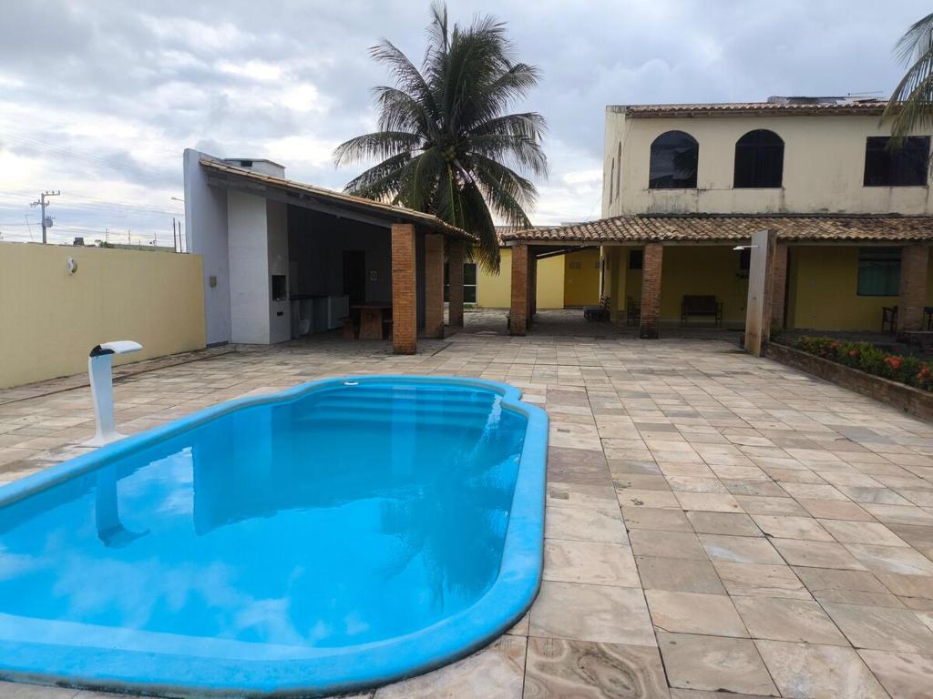 a blue swimming pool in front of a house at Paraíso do Abais, house for rent in Estância