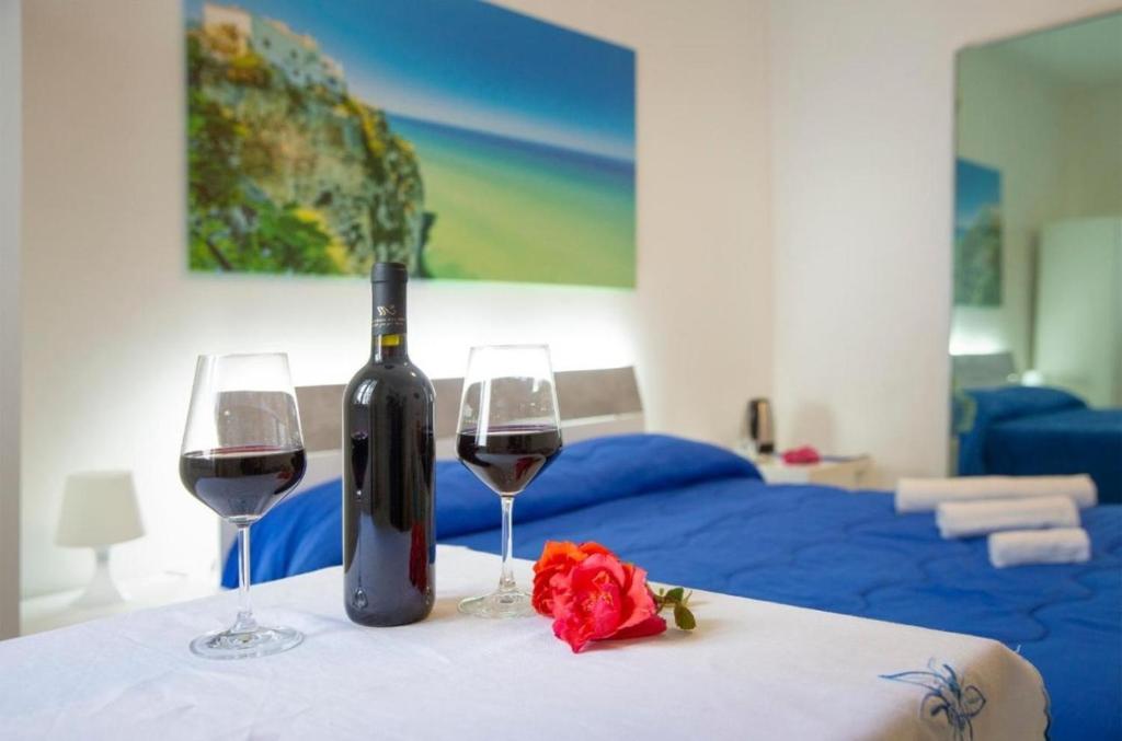 a bottle of wine and two glasses on a table at Anna e Augusto B&B --Embrace the world--4-minute walk from the Old Town丨Authentic local experience丨English-speaking staff and Wi-Fi - free shuttle to the station in Lucera