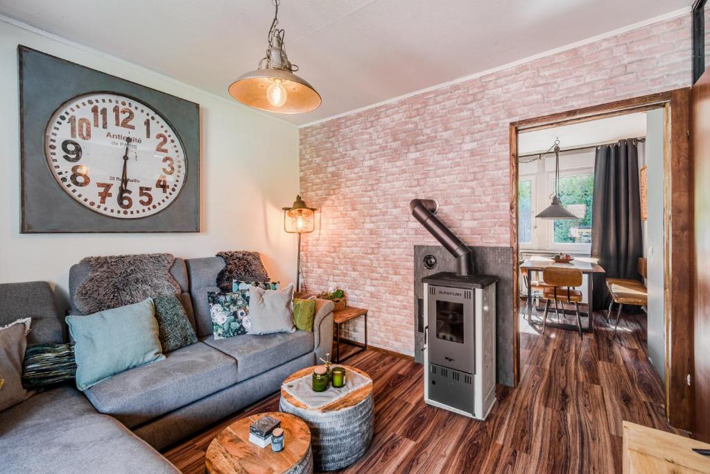 a living room with a couch and a clock on the wall at Hisa Lina near Bovec in Srpenica