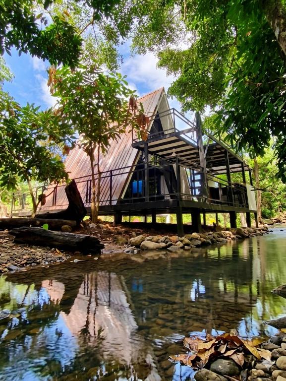 a house on a river with its reflection in the water at Echo Falls Khanom in Ban Nua Tha