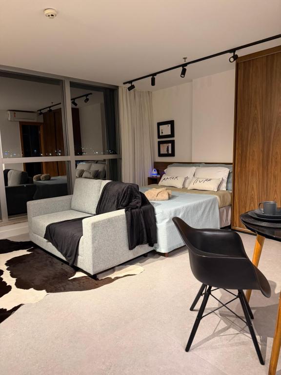 a bedroom with two beds and a chair at 710 A Hotel Home Jade in Brasília