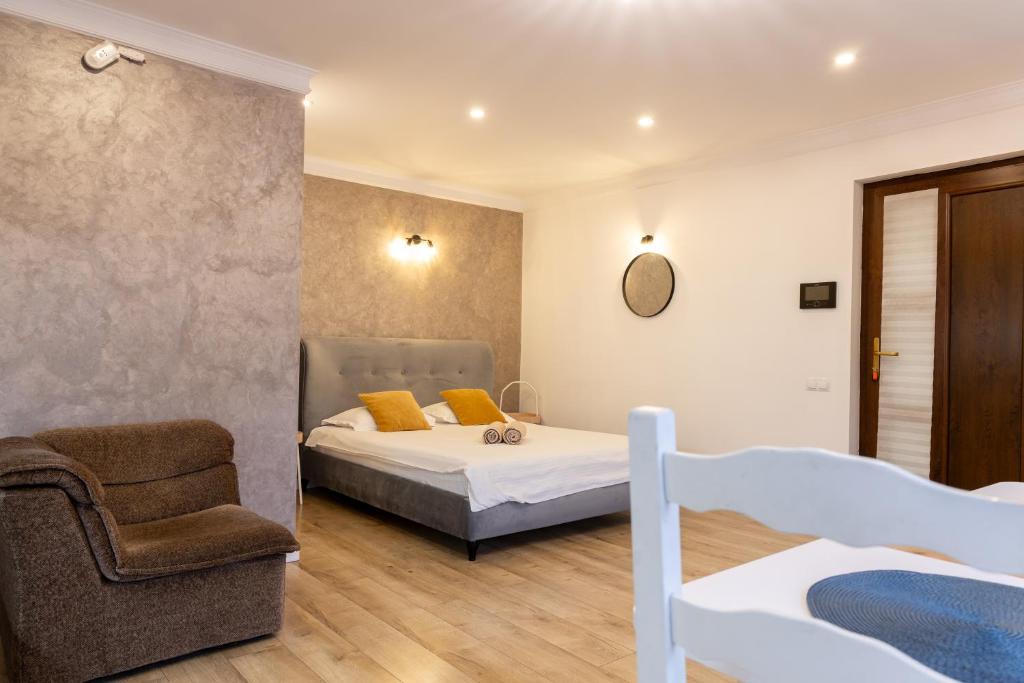 a bedroom with a bed and a chair at Studio Glen in Târgu-Mureş
