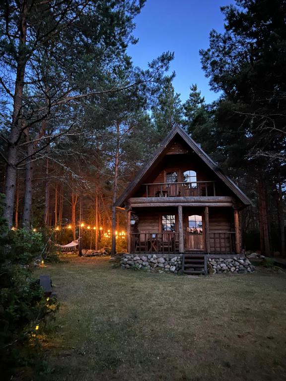 a log cabin in the woods at night at Mõnus palkmaja Muhu mändide all in Nõmmküla
