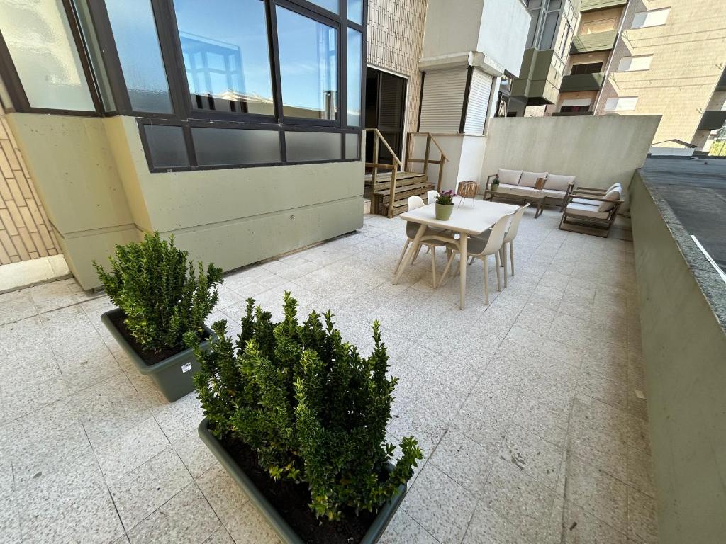 a patio with a table and chairs and plants at The Urban Terrace in Figueira da Foz