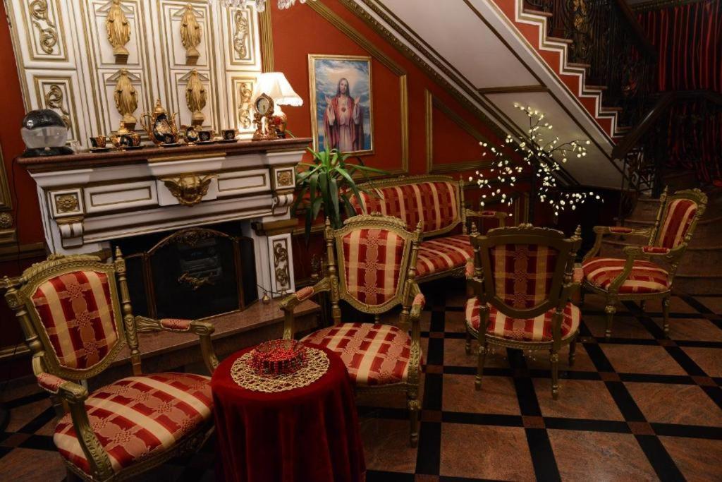 a room with chairs and a fireplace and a table at Guest House Vivaldi in Niš