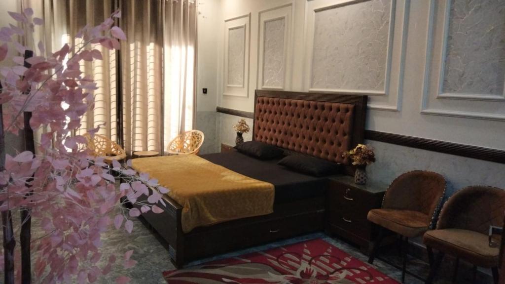 a bedroom with a bed and a table and chairs at SH VILLA Executive in Dhingrānwāli