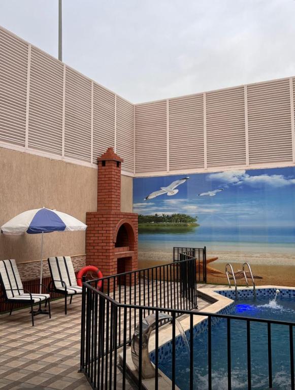 a patio with a swimming pool and a mural of a beach at شاليهات بتلات الورد in Taif
